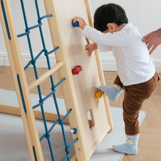 toddler climbing wooden wall structure at home