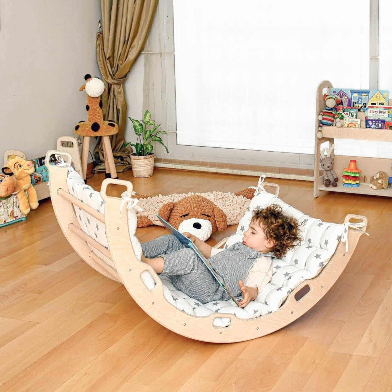 toddler rocking on wooden arch toy at home