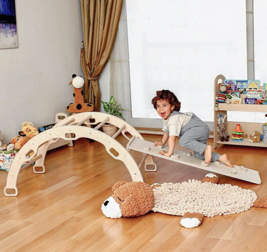 toddler playing with wooden arch rocker indoors