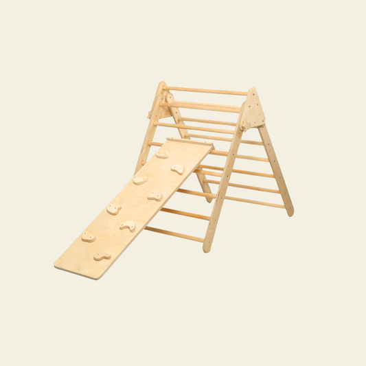 toddler using wooden climbing triangle with ramp indoors
